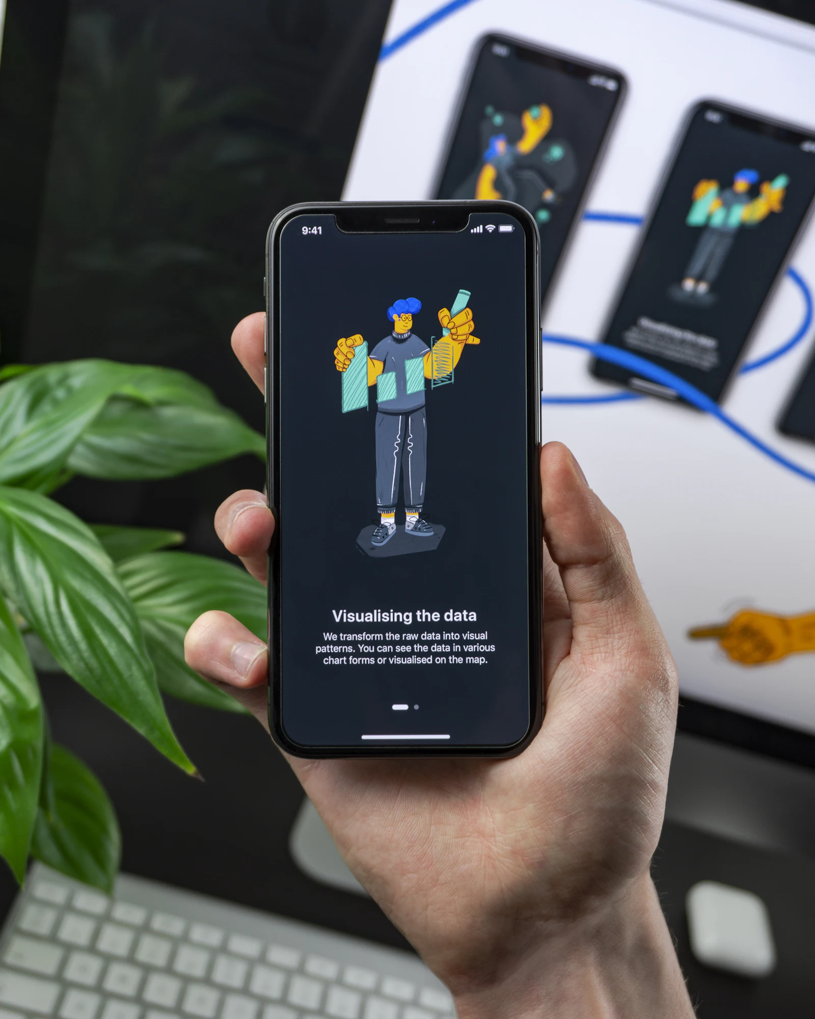 A hand holding a phone that shows an app's onboarding screen
