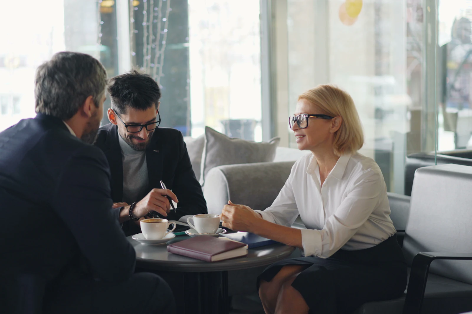 Three people in a meeting around a small table