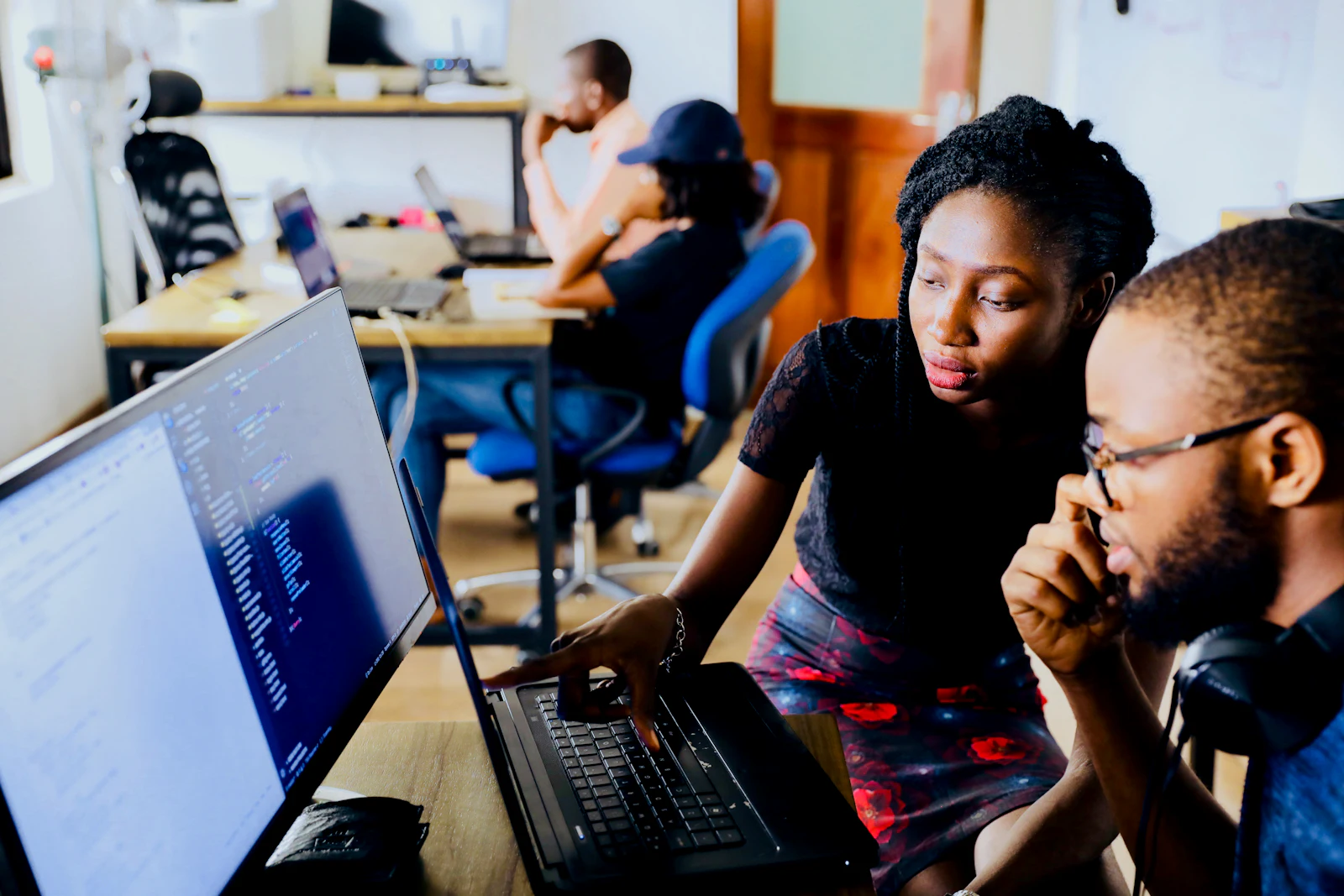 Two developers looking at code on a laptop together