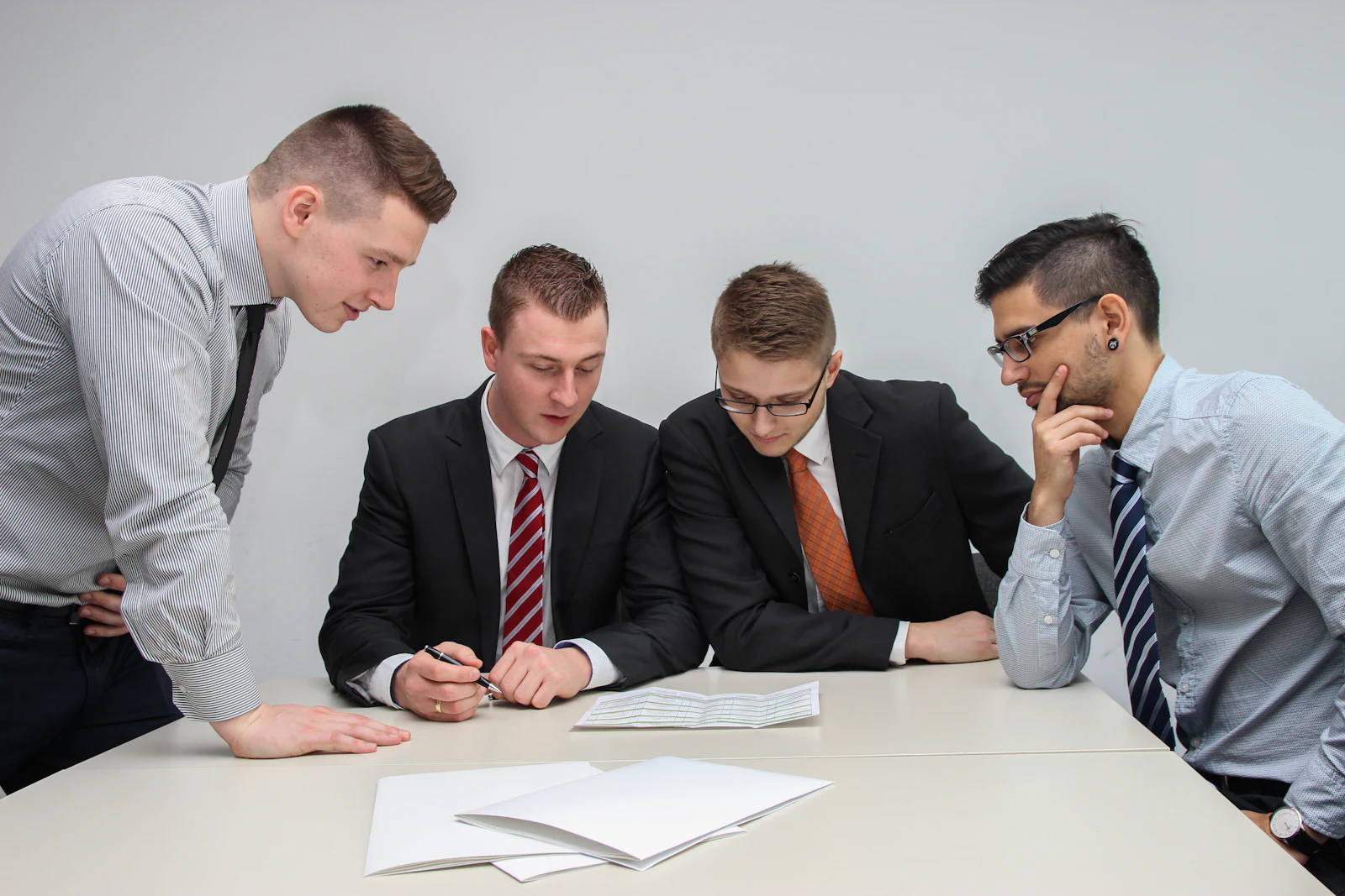 Four people reviewing papers together at a table